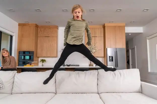 Girl jumping on a Flexsteel sofa